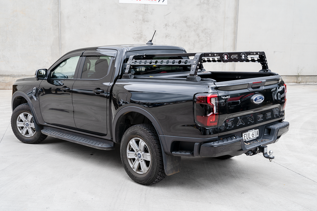Tub Rack and Ute Rack with Roller Tonneau Cover on a Ford Ranger showing car side steps and rear bar parked at Bossco 4x4 Accessories car park